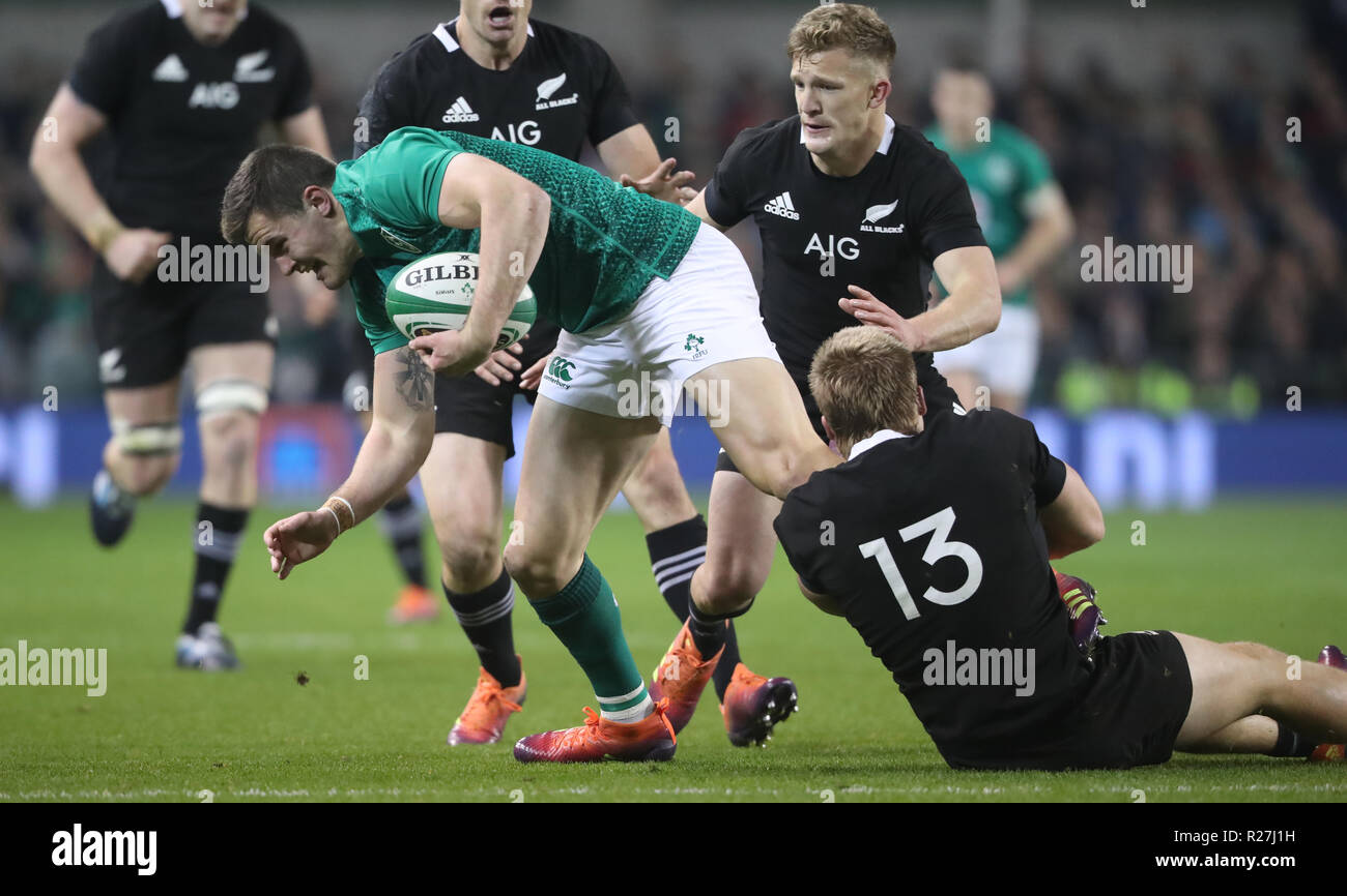 Ireland's Jacob Stockdale is brought down by New Zealand's Jack Goodhue during the Autumn International match at the Aviva Stadium, Dublin Stock Photo