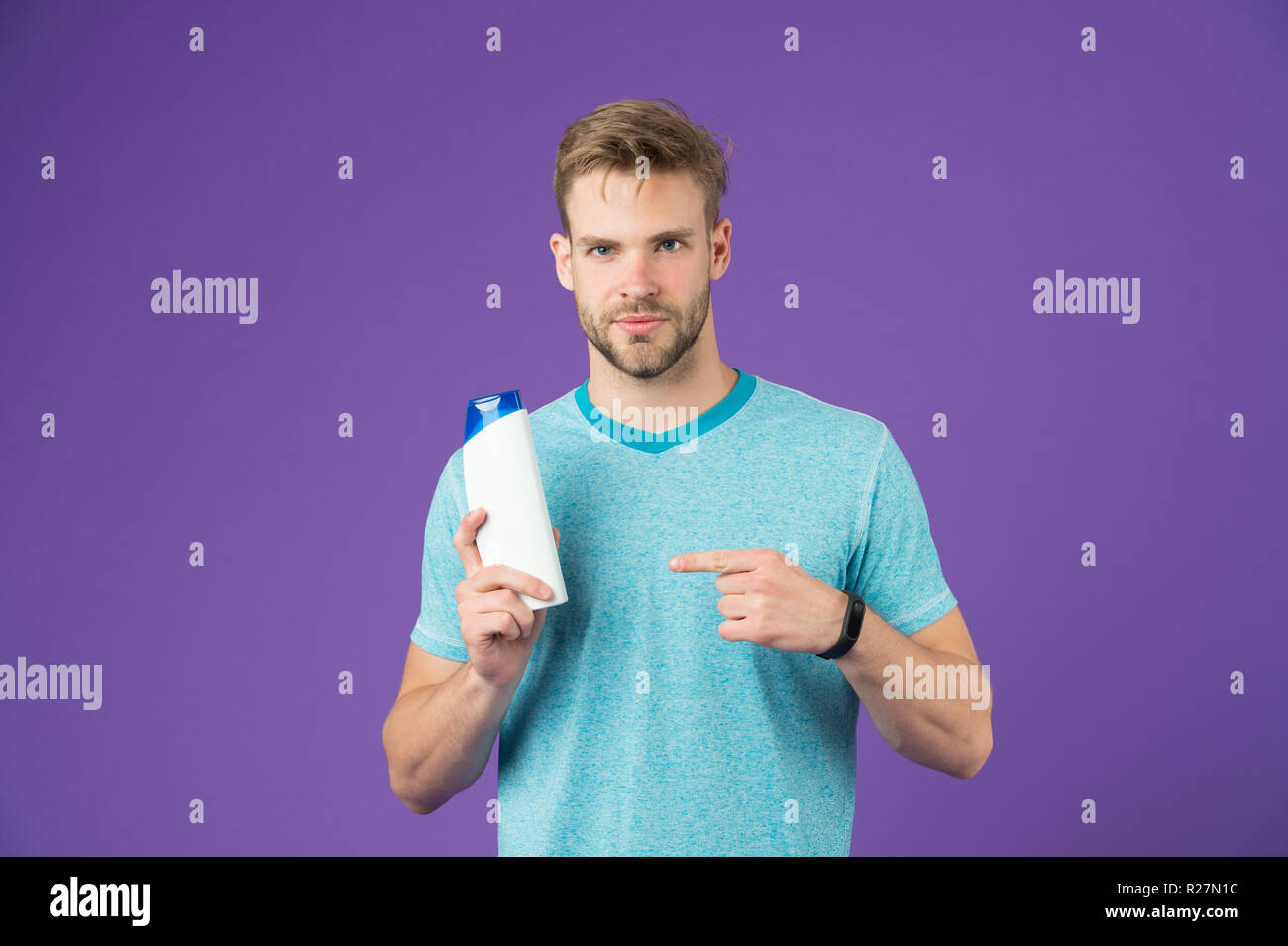 Beauty advice. Man stylish hairstyle holds hair conditioner violet