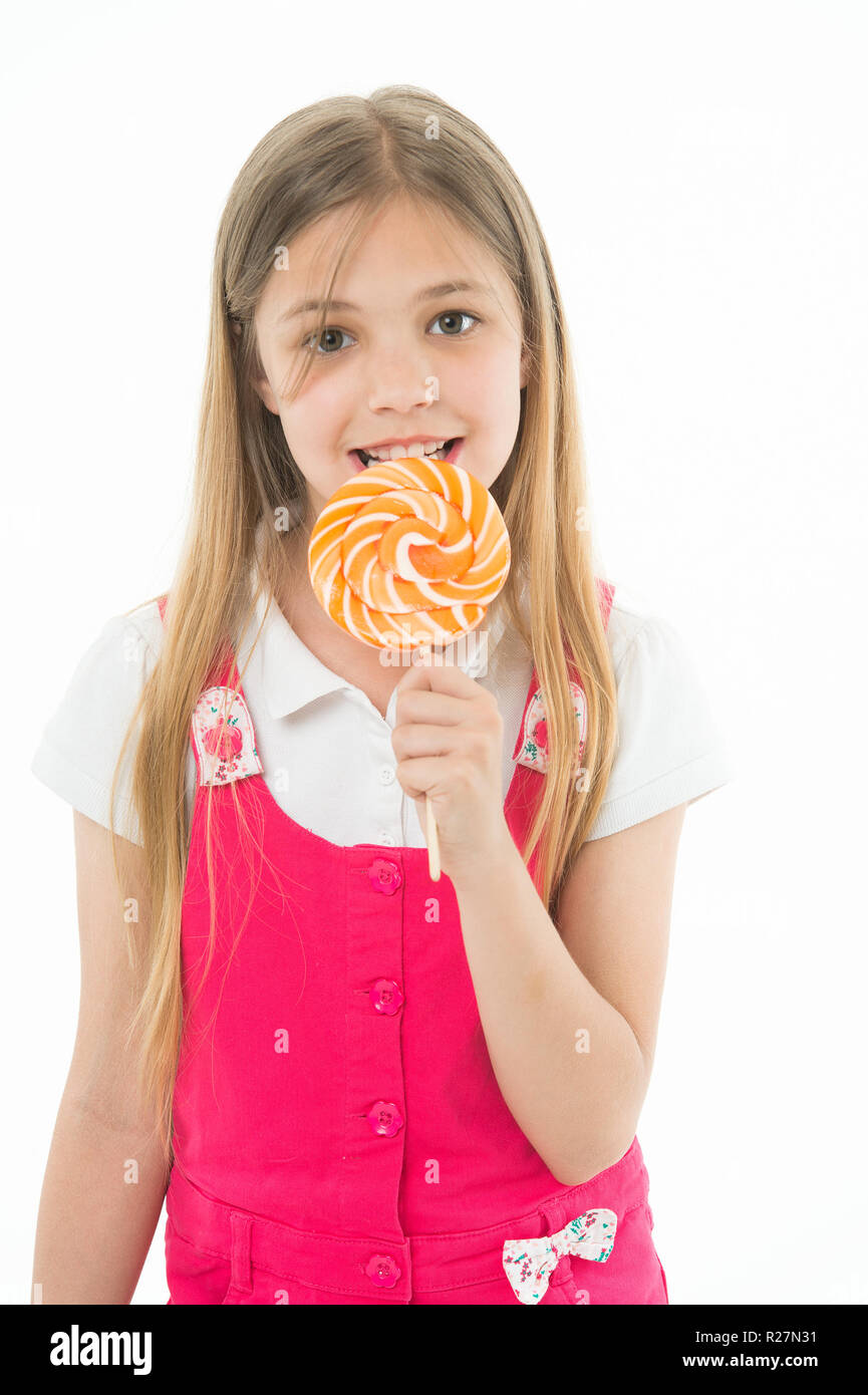 Girl eat lollipop isolated on white. Little child enjoy candy on stick