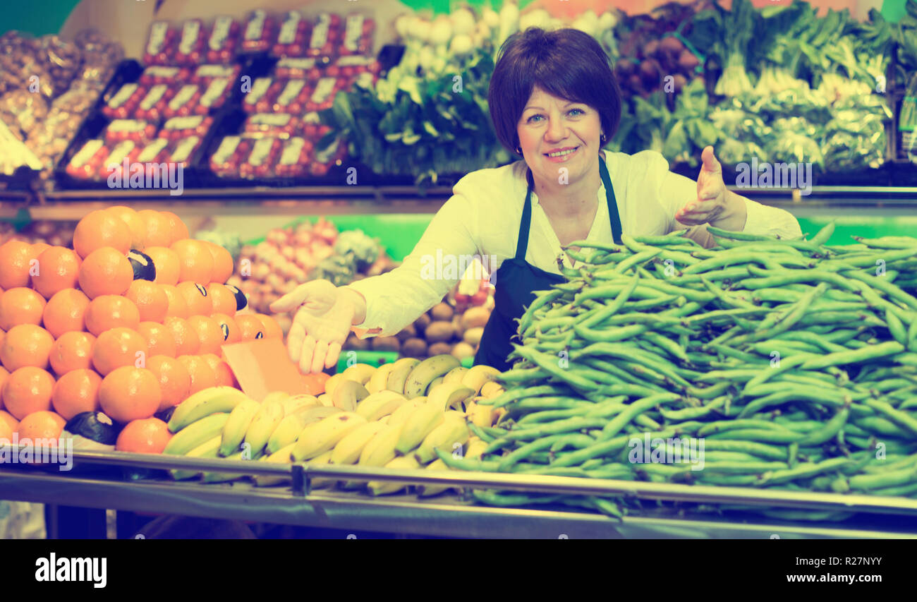 Mature woman offering fresh vegetables and fruits on the market Stock ...
