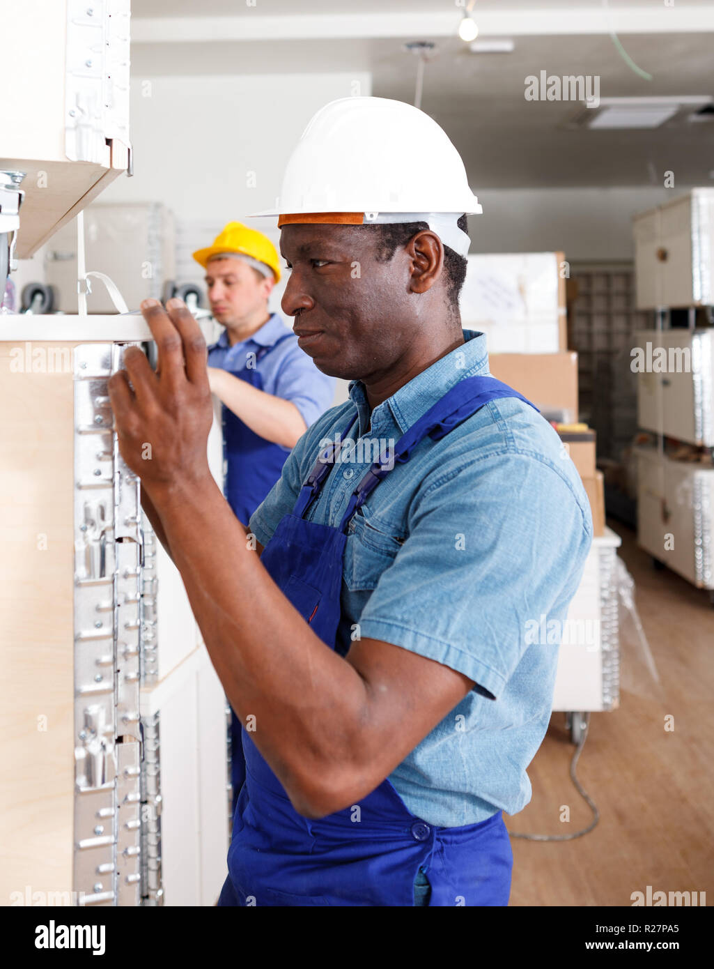 Confident men contractors working on overhauls indoors Stock Photo - Alamy