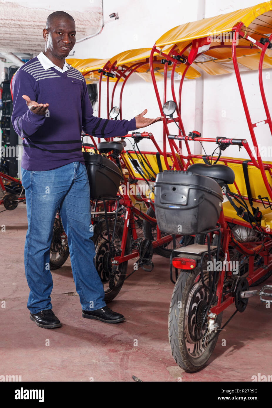 Positive African-American young man offering cycle rickshaw service ...