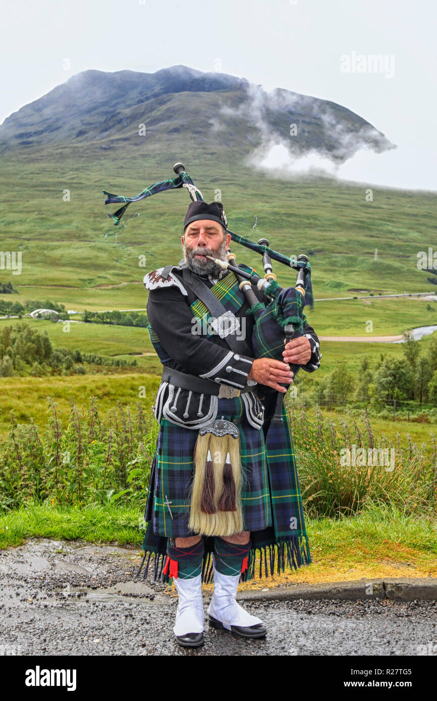 SCOTLAND-JULY, 16TH: Scotsman playing bagpipes on the road in the Highlands on July 16,2011 Stock Photo