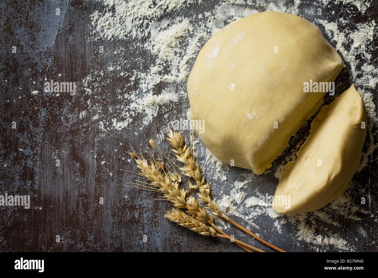 Dough. Fresh raw dough ball for bread or pizza on a dark table, baking background. Top view flat lay background. Copy space. Stock Photo