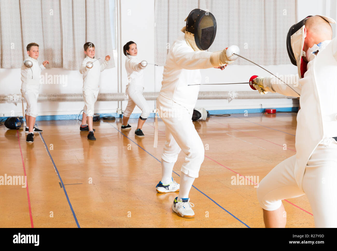 adults and teenagers athletes at fencing coaching, training attack