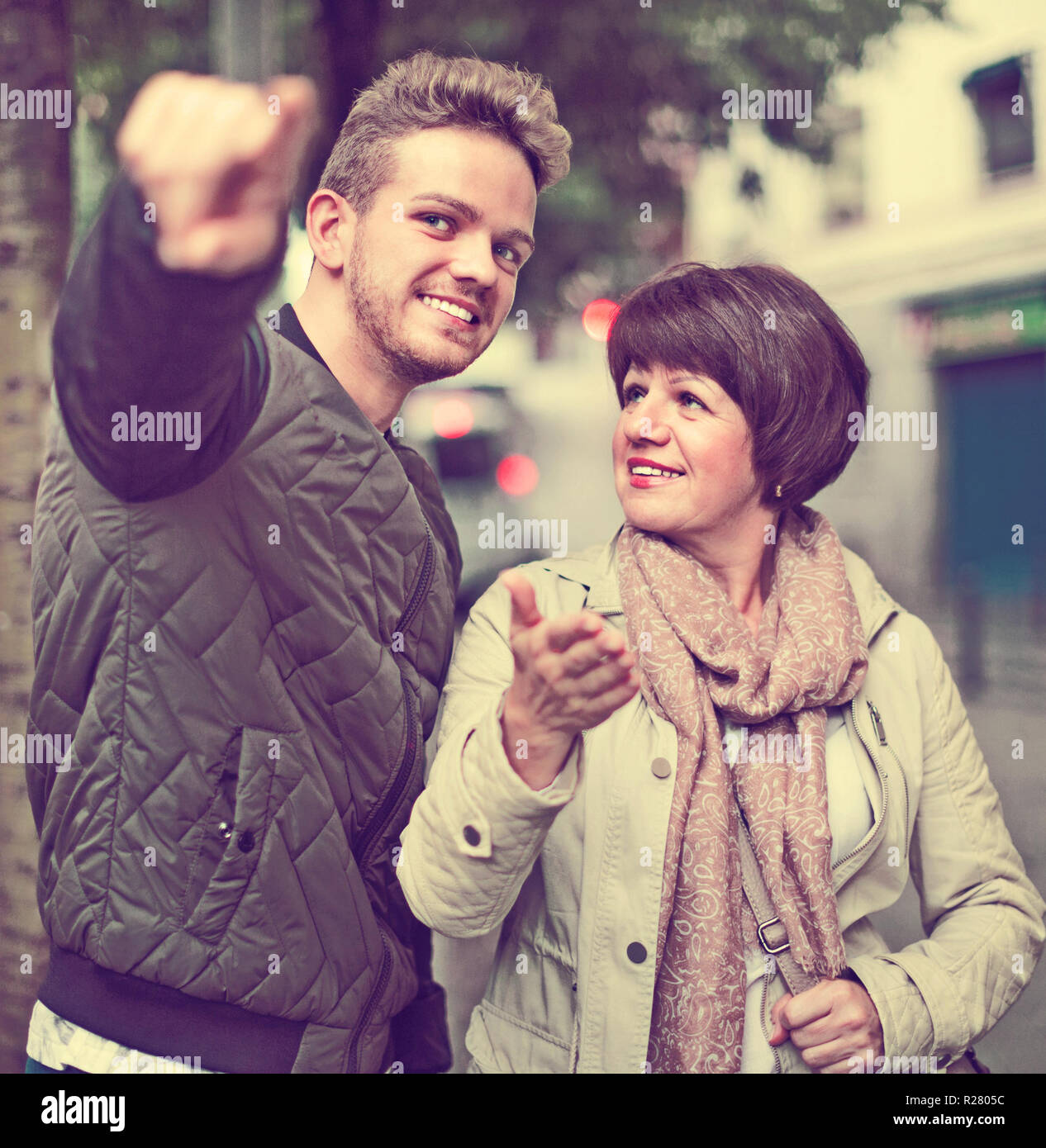Positive male tourist asks for directions from woman Stock Photo Alamy