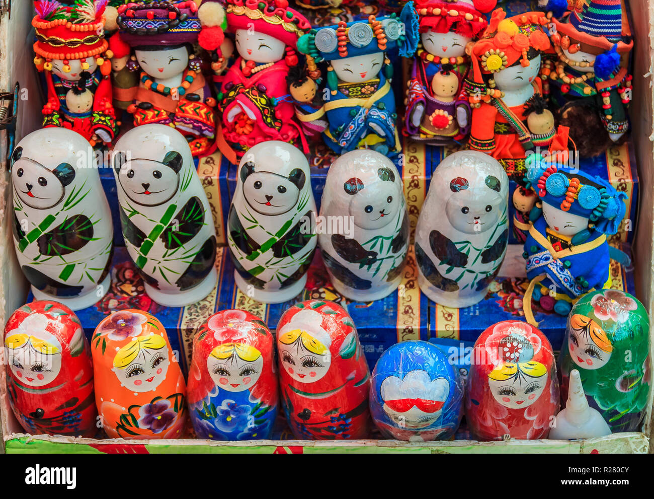 Traditional Chinese dolls and Russian matryoshka along with stylized panda bear nesting toys on display at a souvenir shop by the Great Wall of China  Stock Photo