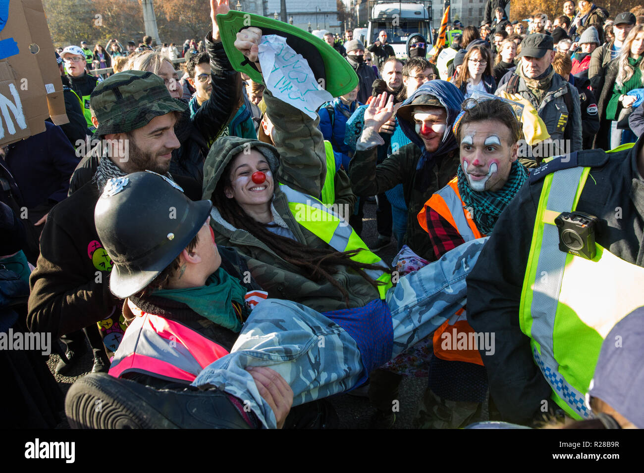 London, UK. 17th November, 2018police officers . Clowns from Clandestine Insurgent Rebel Clown Army (CIRCA) follow police officers arrestingt a man after environmental campaigners from Extinction Rebellion blocked Lambeth Bridge, one of five bridges blocked in central London, as part of a Rebellion Day event to highlight 'criminal inaction in the face of climate change catastrophe and ecological collapse' by the UK Government as part of a programme of civil disobedience during which scores of campaigners have been arrested. Credit: Mark Kerrison/Alamy Live News Stock Photo