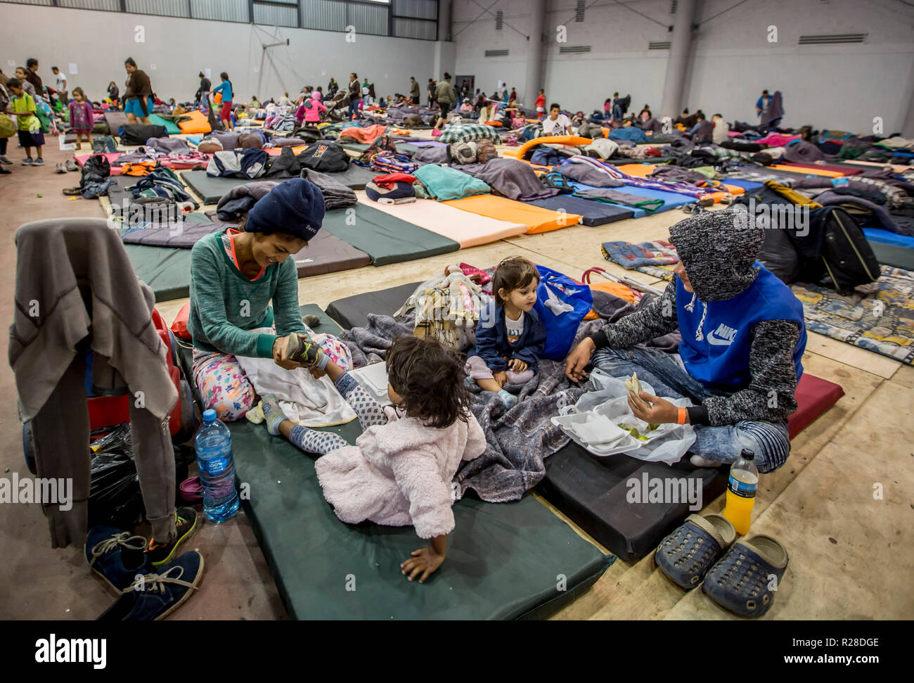 Tijuana, Mexico. 17th Nov, 2018. Migrants rest at the Benito Juárez sports complex in Tijuana. Between 2000 and 2500 migrants are accommodated there. The hostels in Tijuana are full - authorities estimated that a total of about 9600 people will arrive in the border city with several so-called migrant caravans. They all have a common goal: The United States. People flee violence and unemployment in their home countries. Credit: Omar Martinez/dpa/Alamy Live News Stock Photo