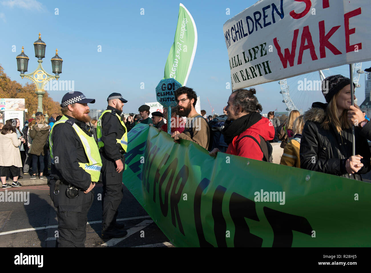 Environmental activist seen talking with a police officer.  The Extinction Rebellion activists gathered at five main bridges in London, to raise their concerns about climate change and demand that the UK government commits to reducing  carbon emissions to zero by 2025. Stock Photo