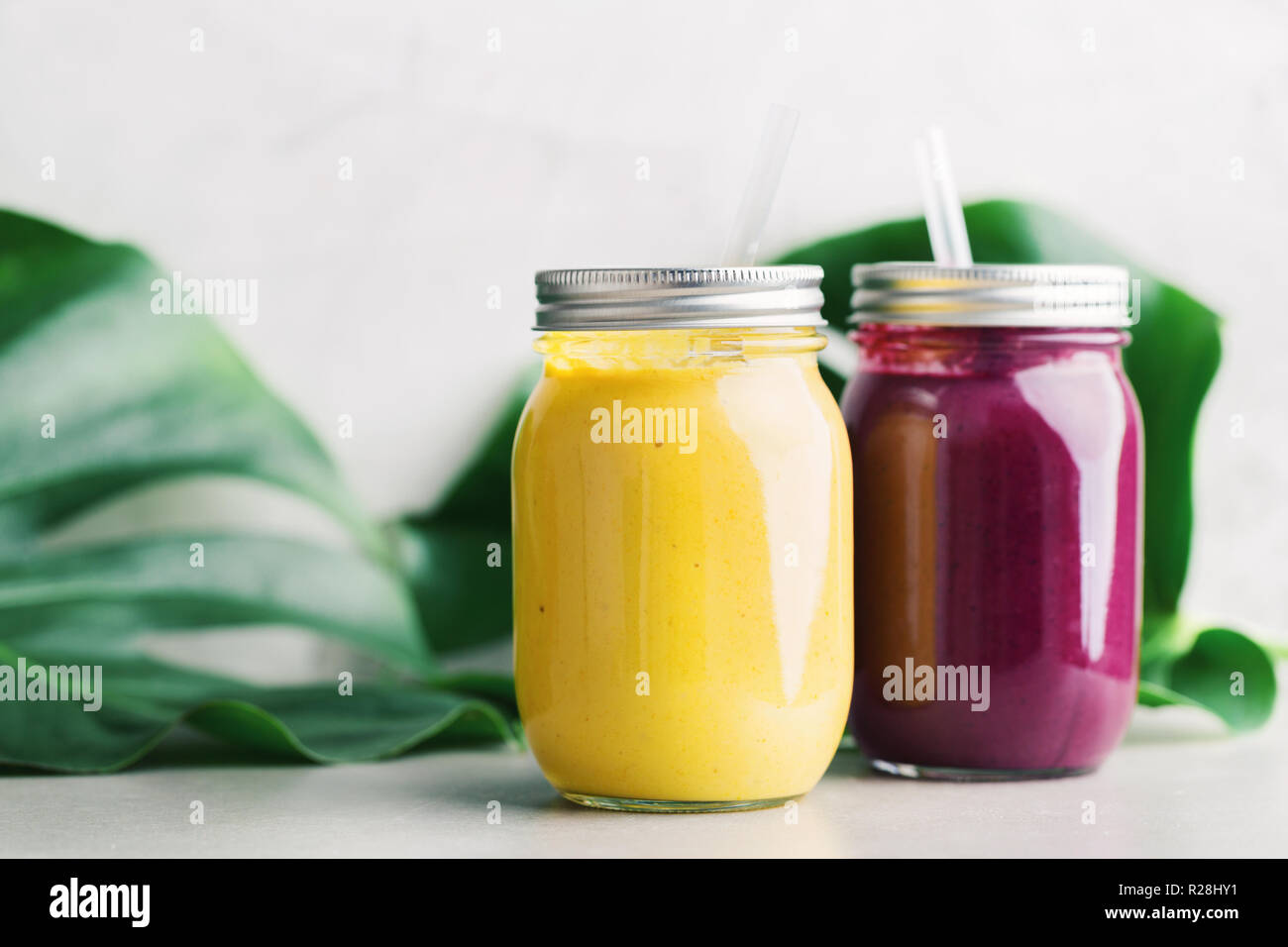 Tasty Appetizing Fresh Made Fruit Smoothies In Jars On Grey Table tasty-appetizing-fresh-made-fruit-smoothies-in-jars-on-grey-table