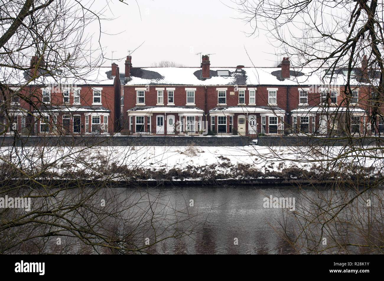 A winter view from the riverside of snow covered terraced houses in Worcester after the 'Beast of the East' storm. City snow scenery. Stock Photo