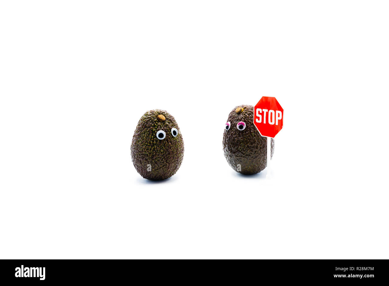 Romantic avocados couple with googly eyes as man and woman, STOP traffic sign, funny food concept for creative projects. Stock Photo