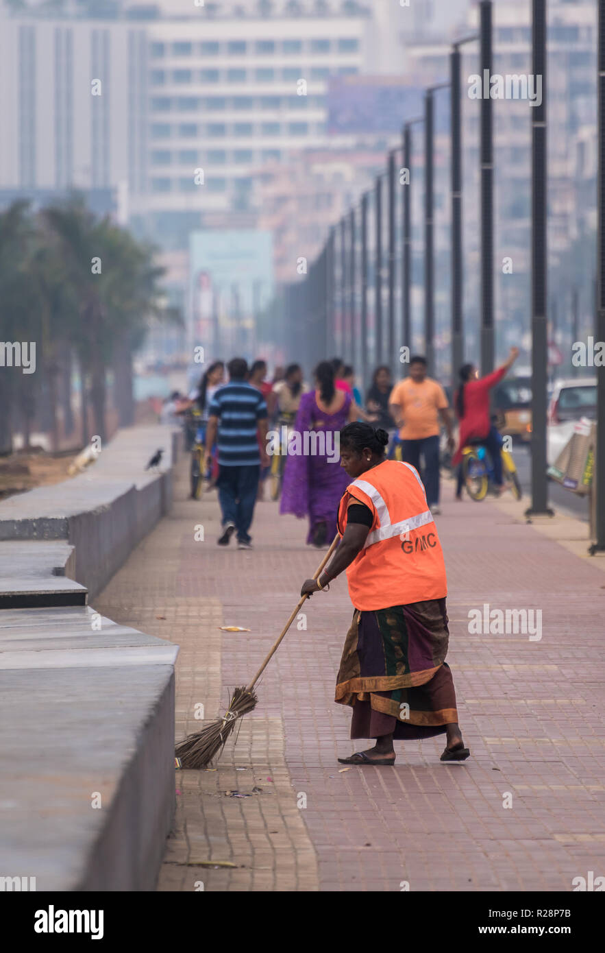November 12,2018. visakhapatnam, india. A Lady Sweeper wipes the Beach road of RK Beach ant the morning. Stock Photo