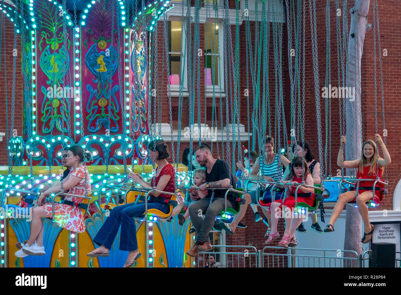 People sitting on a carousel waiting  for the ride to start Christmas festival Perth Western Australia. Stock Photo