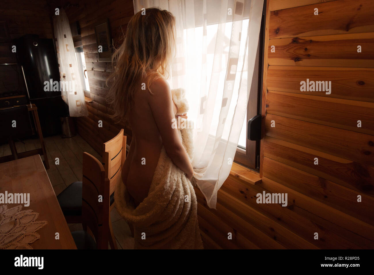 Naked girl on a bed in a wooden house Stock Photo - Alamy