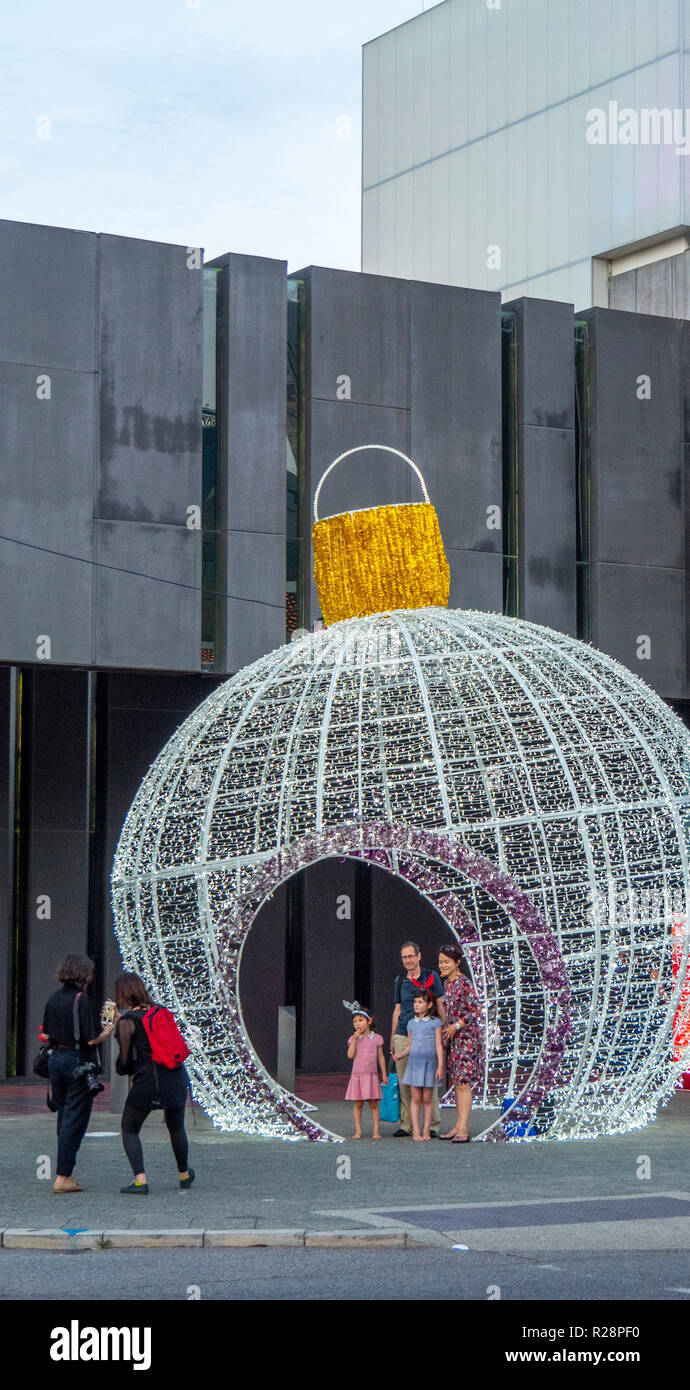 Family posing for a photograph standing inside giant bauble State