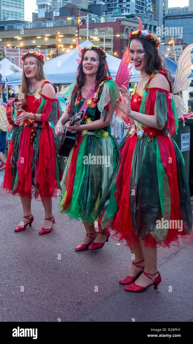 Three female elves singing Christmas Carols Yagan Square Perth Western Australia. Stock Photo