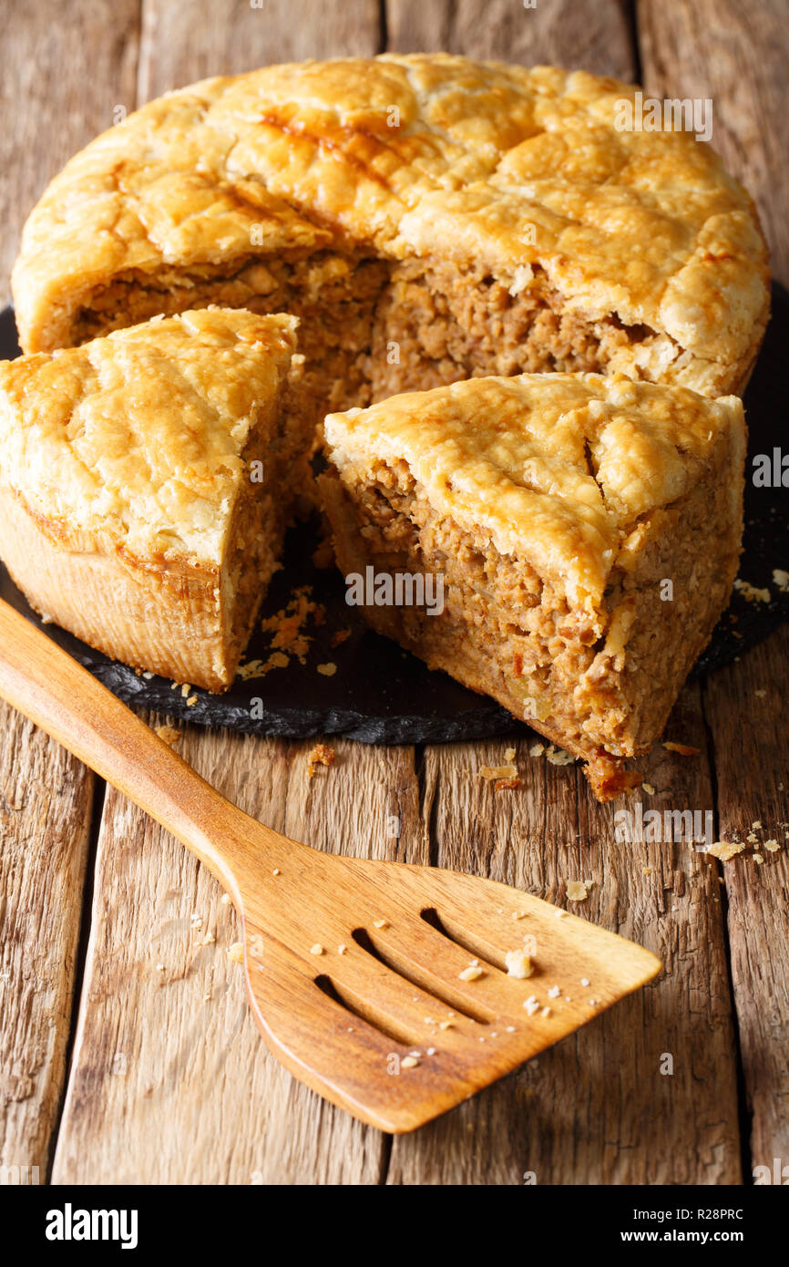 Sliced homemade  tourtiere pie with pork, mashed potatoes and spices close-up on the table. vertical Stock Photo