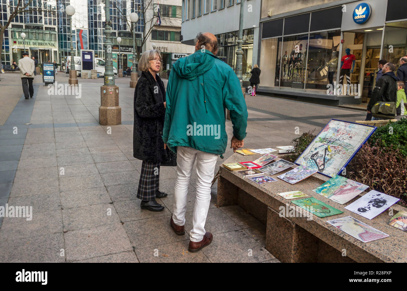 Zagreb, Croatia, November 2018 - An artist discussing with a potential customer about his paintings at Bogiceva Street Stock Photo