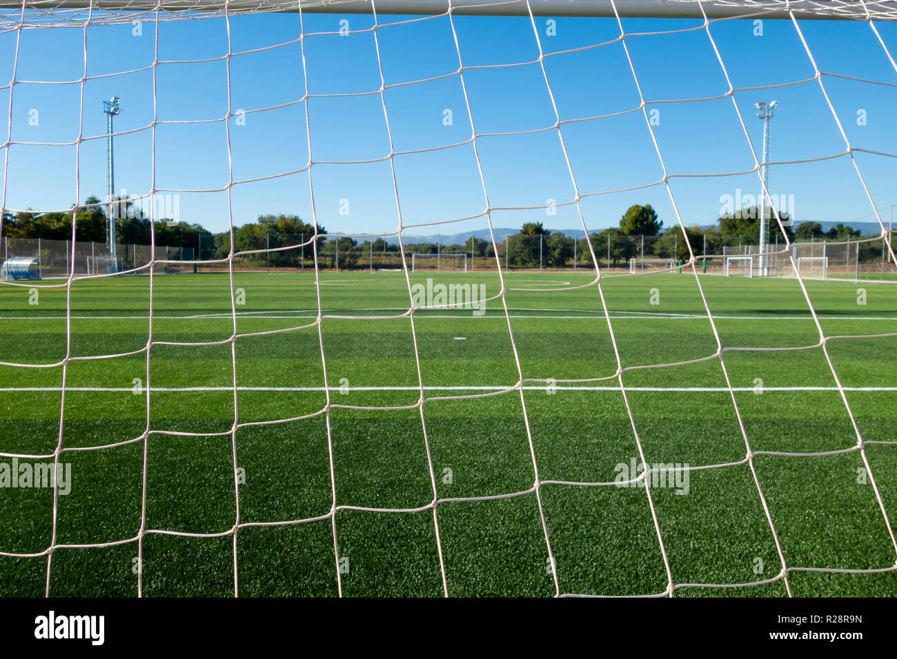 Soccer field through the goal net in a sports complex Stock Photo Alamy