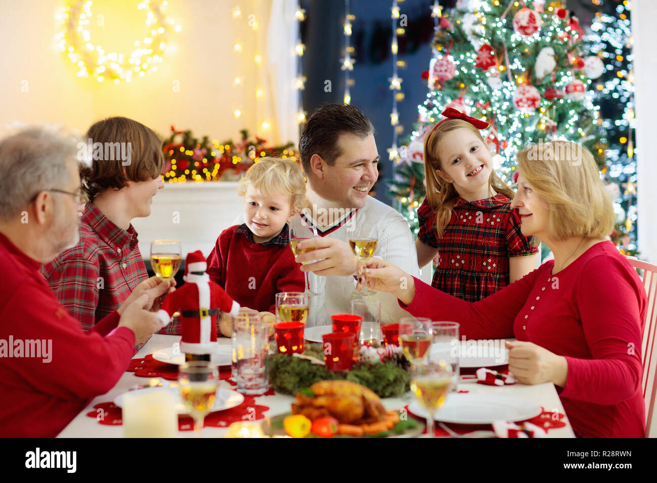 Family With Children Eating Christmas Dinner At Fireplace And Decorated Xmas Tree Parents Grandparents And Kids At Festive Meal Winter Holidays Cel Stock Photo Alamy