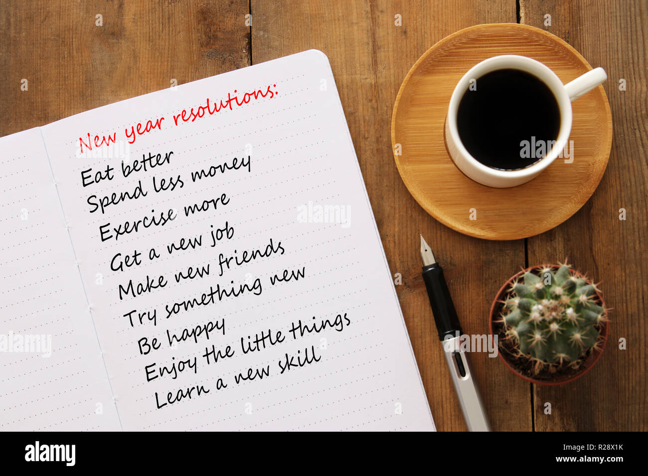 Top view of new year resolutions list with notebook, cup of coffee over  wooden desk Stock Photo - Alamy