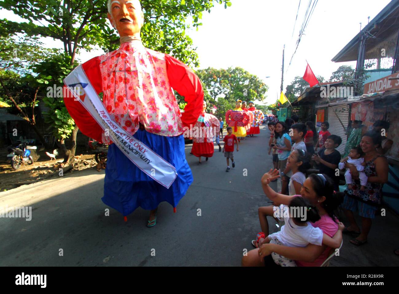 Philippines. 18th Nov, 2018. Higantes (Giant) effigy marches on the streets town of Angono province of Rizal on November 18, 2018. Higantes (Giant) Festival is celebrated November in the city of Angono, Province of Rizal in the Philippines to honor San Clemente, the patron saint of fishermen. The festival features a parade of hundreds of higantes, papier-mâché giants. Higantes (Giant) are puppets rendered as man or woman in various costumes; their face gives a commanding look, their hands on the waist. Credit: Gregorio B. Dantes Jr./Pacific Press/Alamy Live News Stock Photo