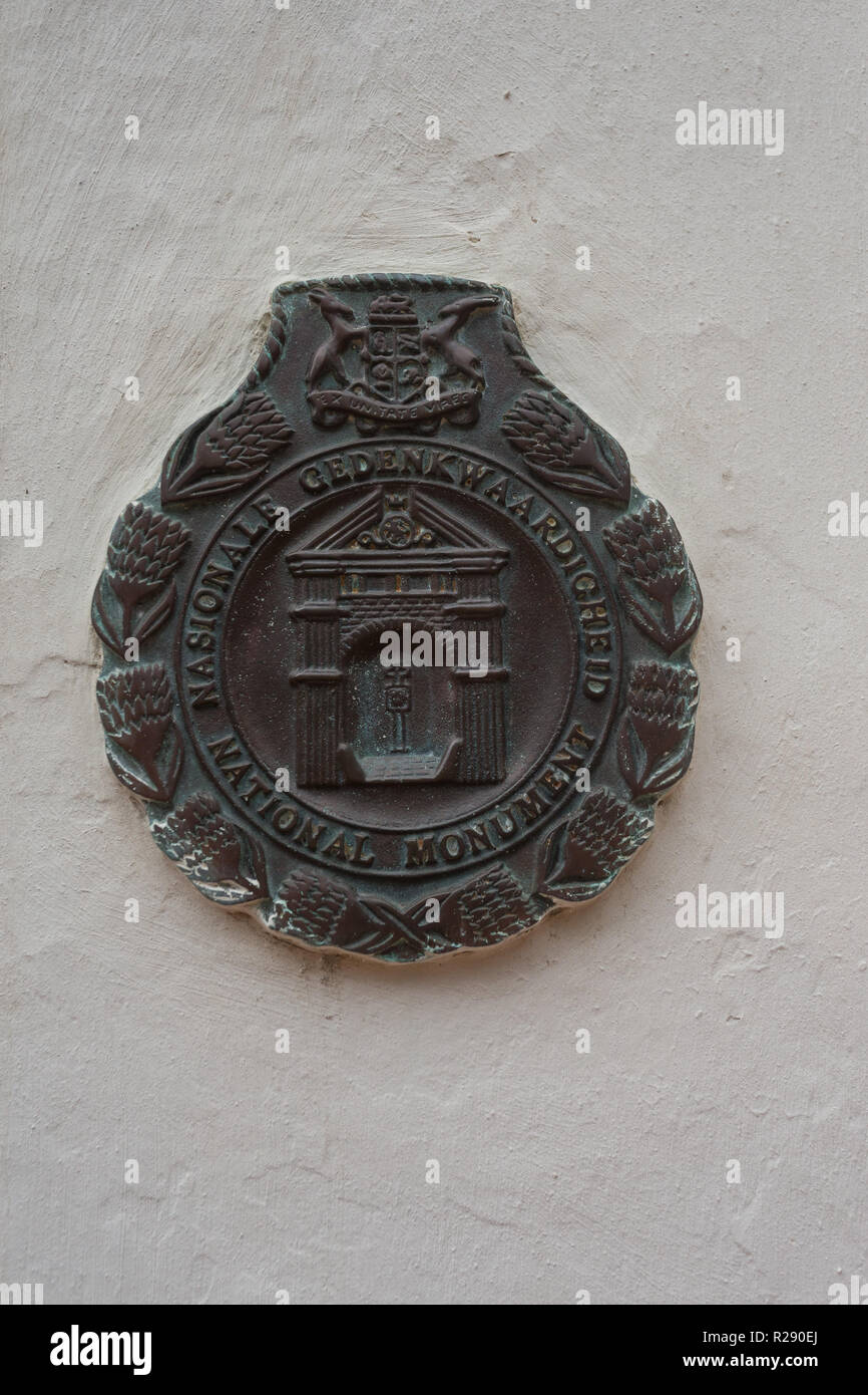 bronze plaque on external or exterior white wall of building depicting National monument status in South Africa with historical merit Stock Photo