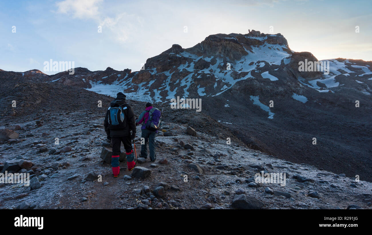 Couple of climbers walking early in the morning towards the Carihuairazo mountain in Ecuador Stock Photo