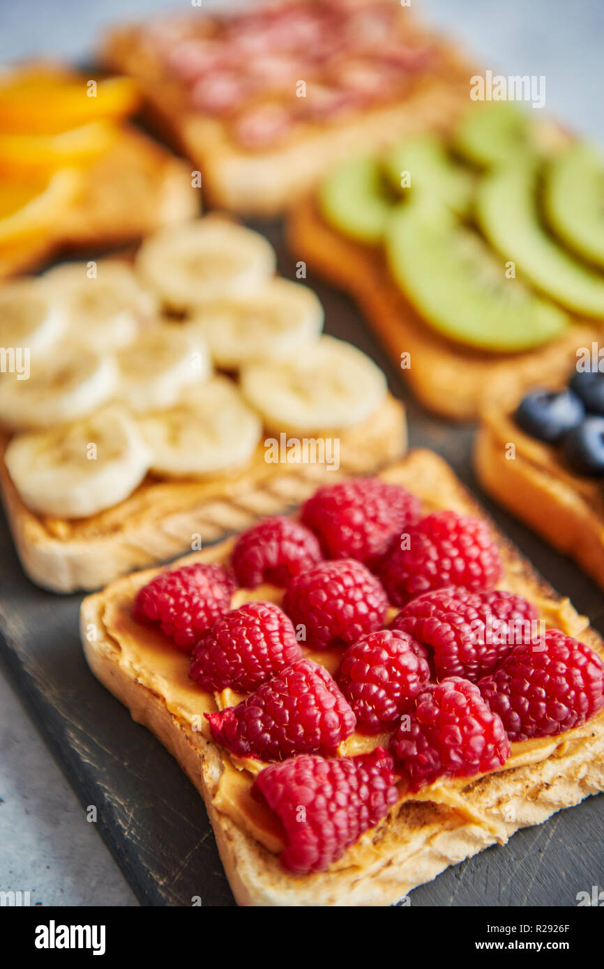 Wholegrain bread slices with peanut butter and various fruits Stock
