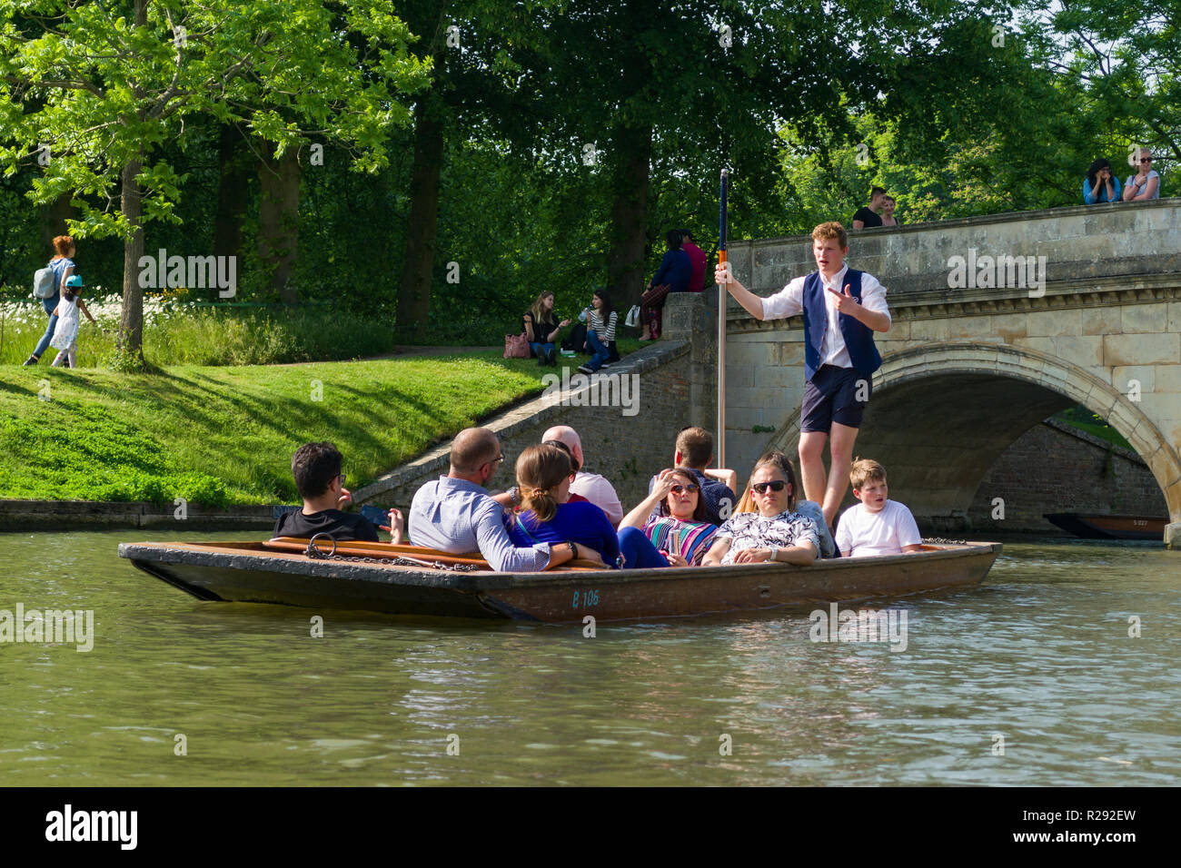 A group of tourists taking a guided tour in a punt boat with chauffeur talking to them, Cambridge, UK Stock Photo