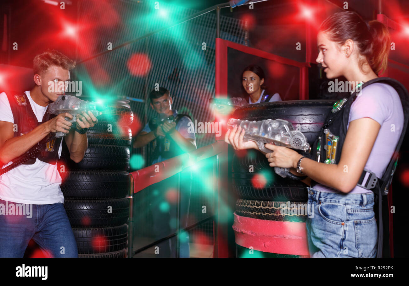 Group portrait of nice emotional people with laser guns playing laser tag  game together in dark labyrinth Stock Photo - Alamy