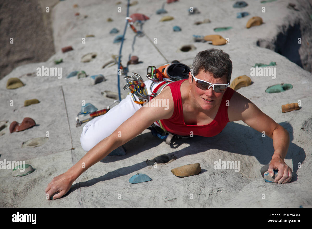 Woman with sunglasses climbs an artificial climbing facility at the climbing tower, Germany Stock Photo