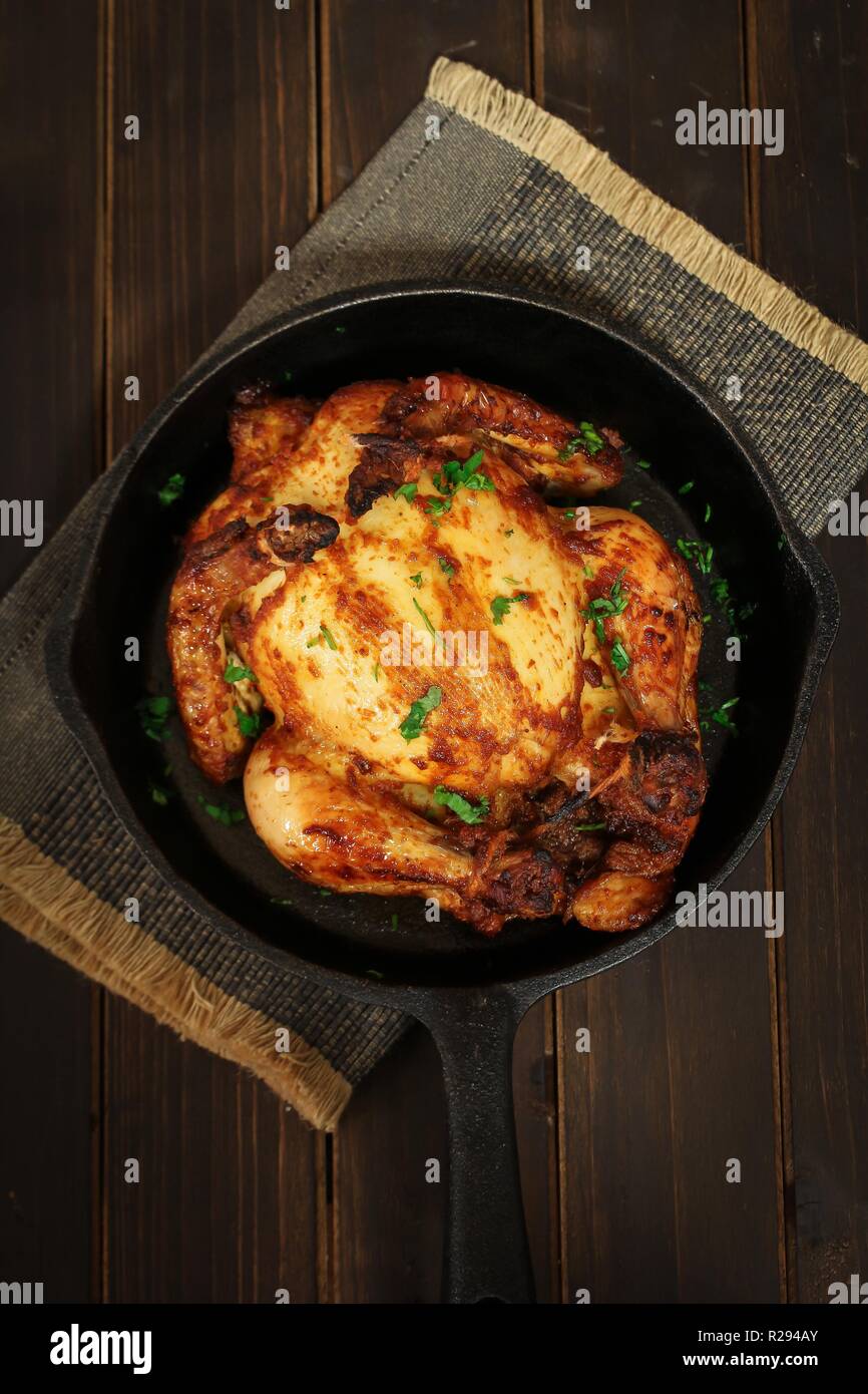 Thanksgiving Xmas Dinner Whole Chicken Roast or Cornish hen baked with masala herb, rustic overhead view Stock Photo