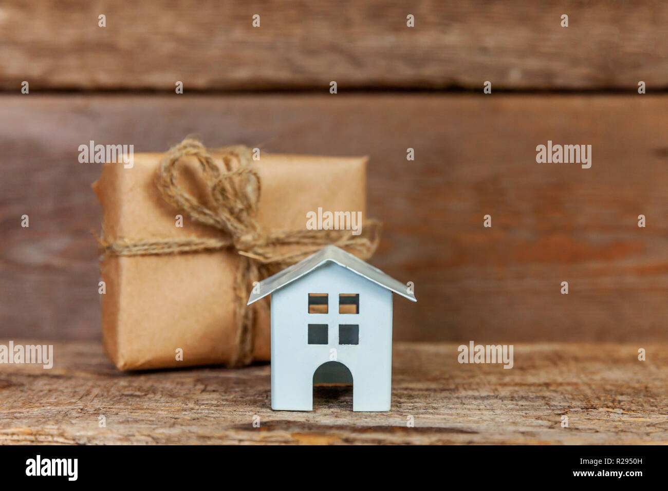Miniature white toy house and gift box wrapped craft paper on old shabby  rustic wooden background. Mortgage property insurance dream home concept.  Buy Stock Photo - Alamy