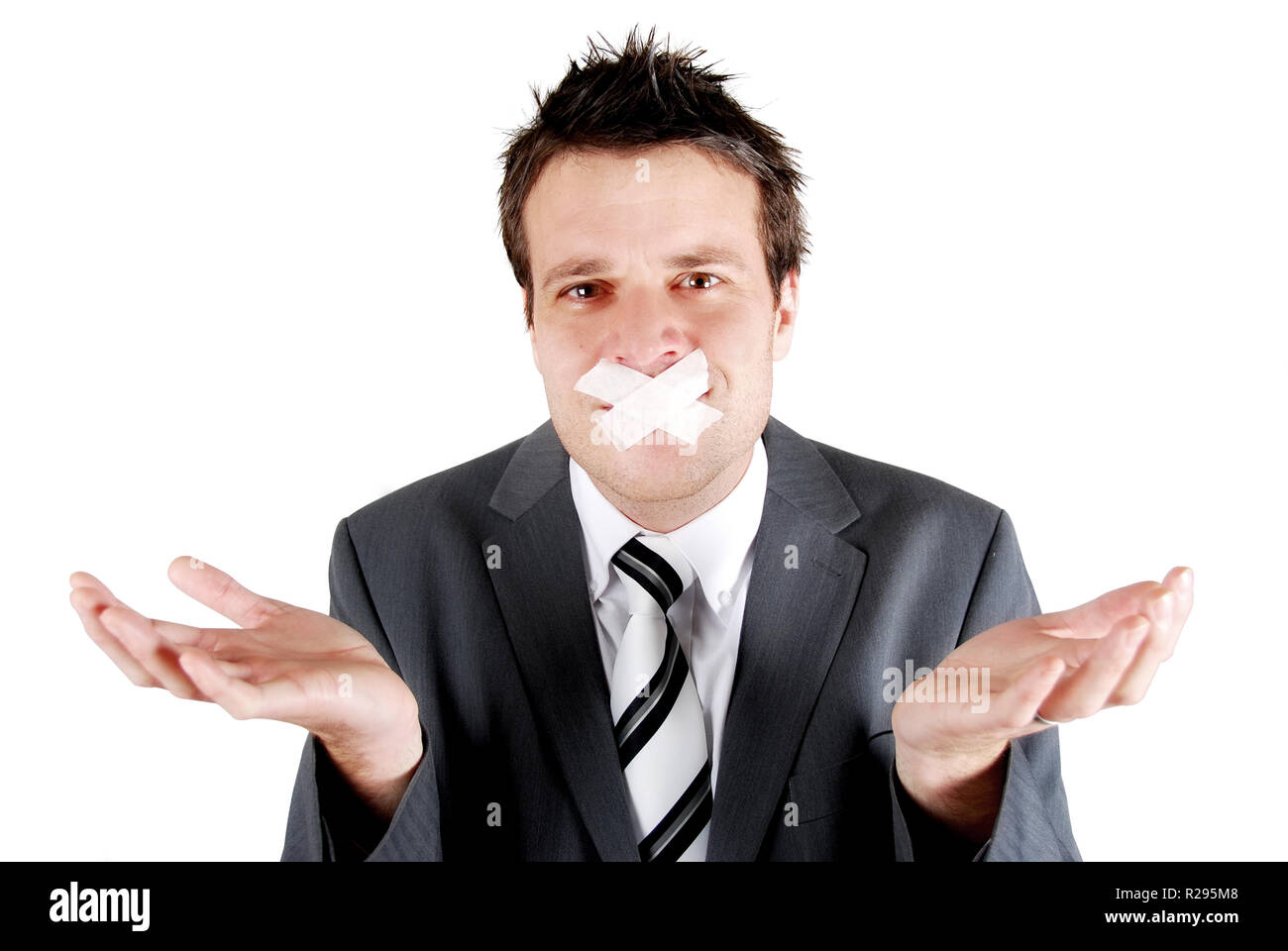 Man with tape over his mouth in a gesturing pose of speachlessness Stock Photo