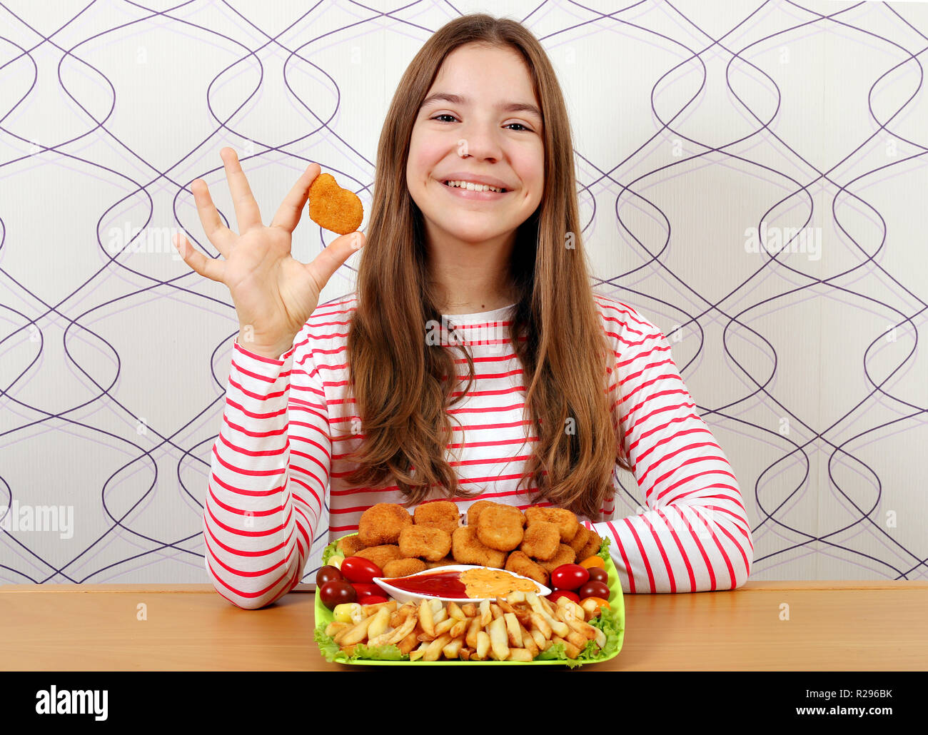 Happy teenage girl with chicken nuggets and french fries fast food