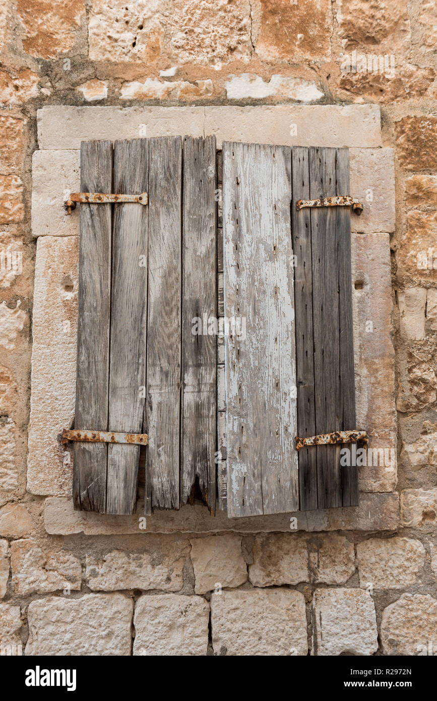 Old retro wooden shutters on window. Old stone house. Exterior detail. Wooden window. Stock Photo