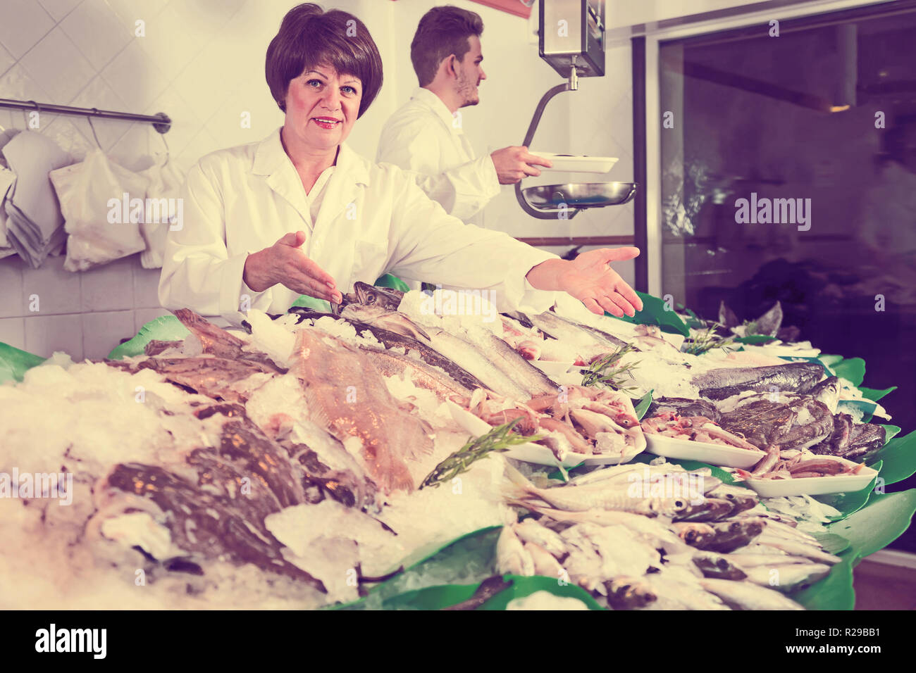 Fish and seafood store with two friendly sellers indoors Stock Photo