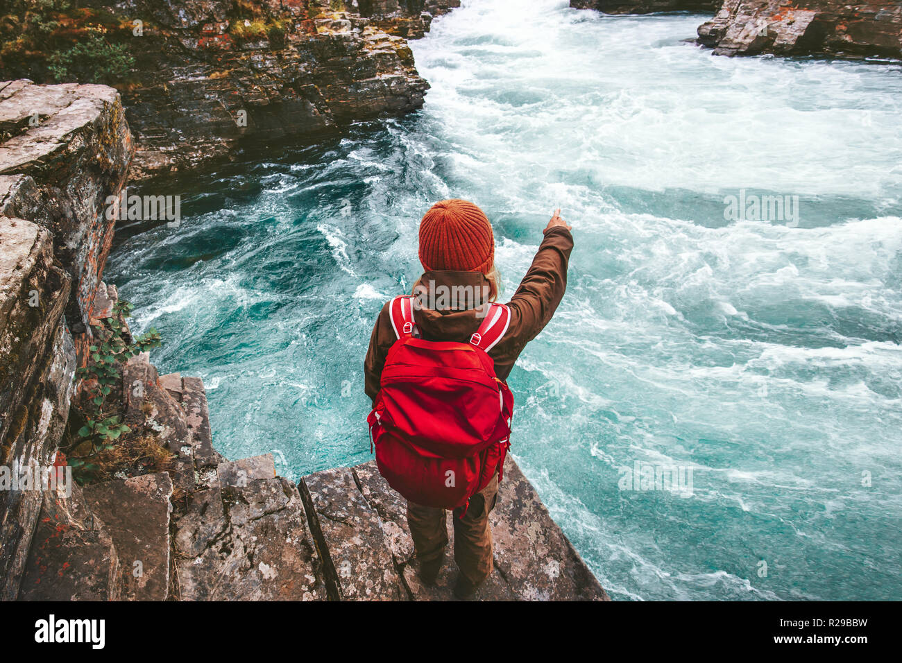 Backpacker traveling alone active  lifestyle hiking at river canyon adventure vacations outdoor woman hand showing location Stock Photo