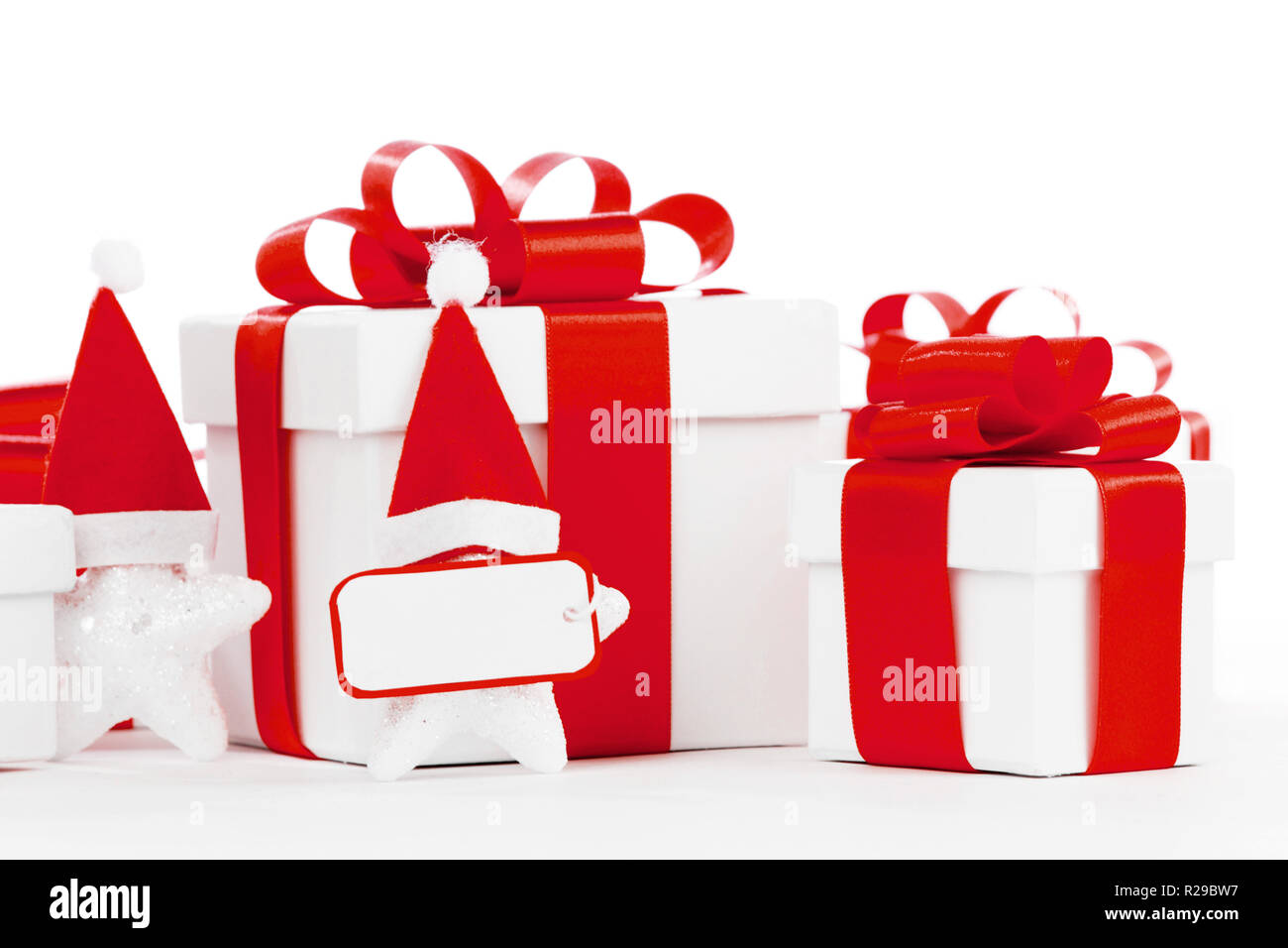 White gift box with red ribbon, stars with santa claus hats isolated on ...