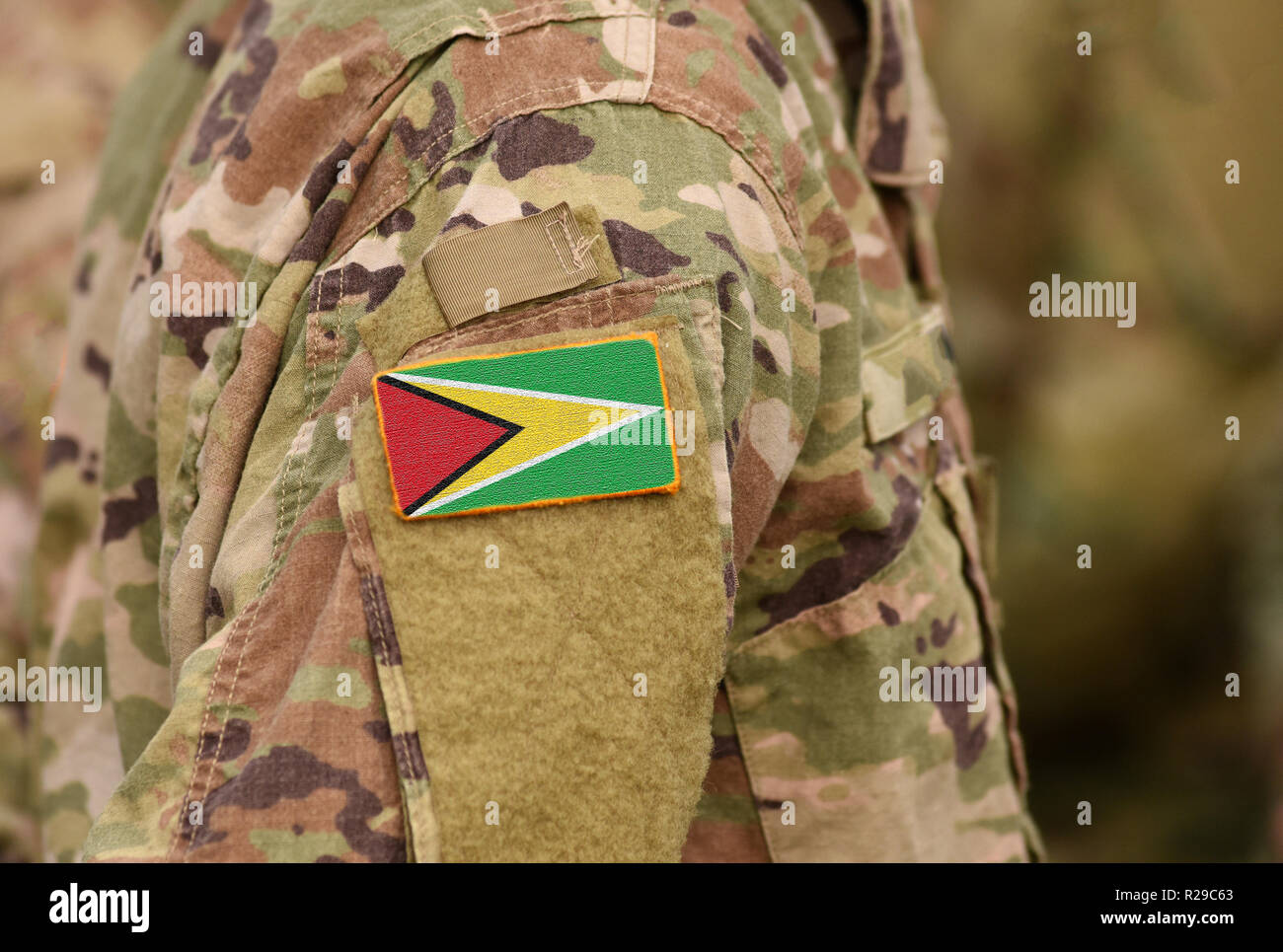 Guyana flag on soldiers arm. Co-operative Republic of Guyana troops (collage) Stock Photo