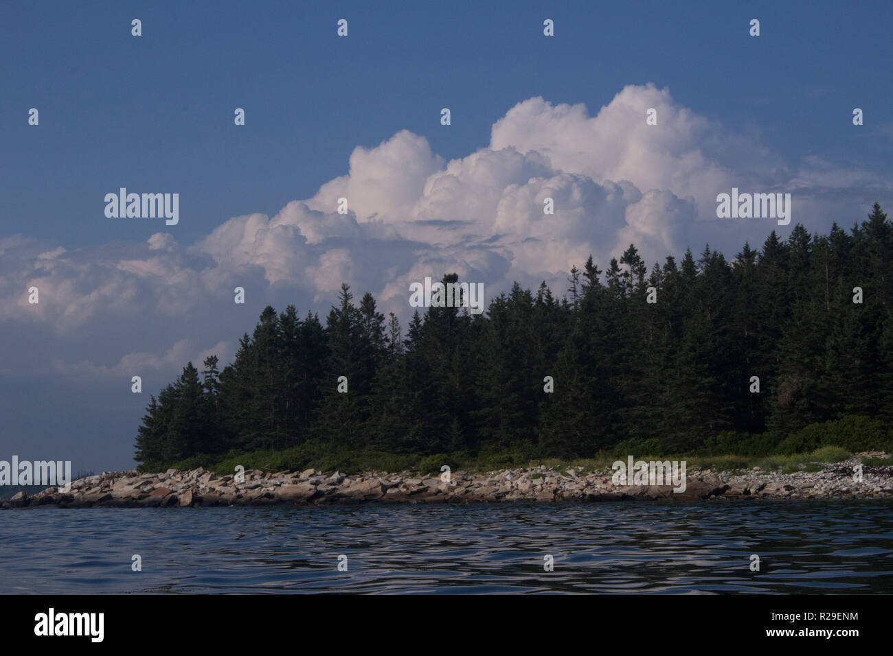 Puffy Clouds hover above Spruce Island on the Maine coast. Stock Photo