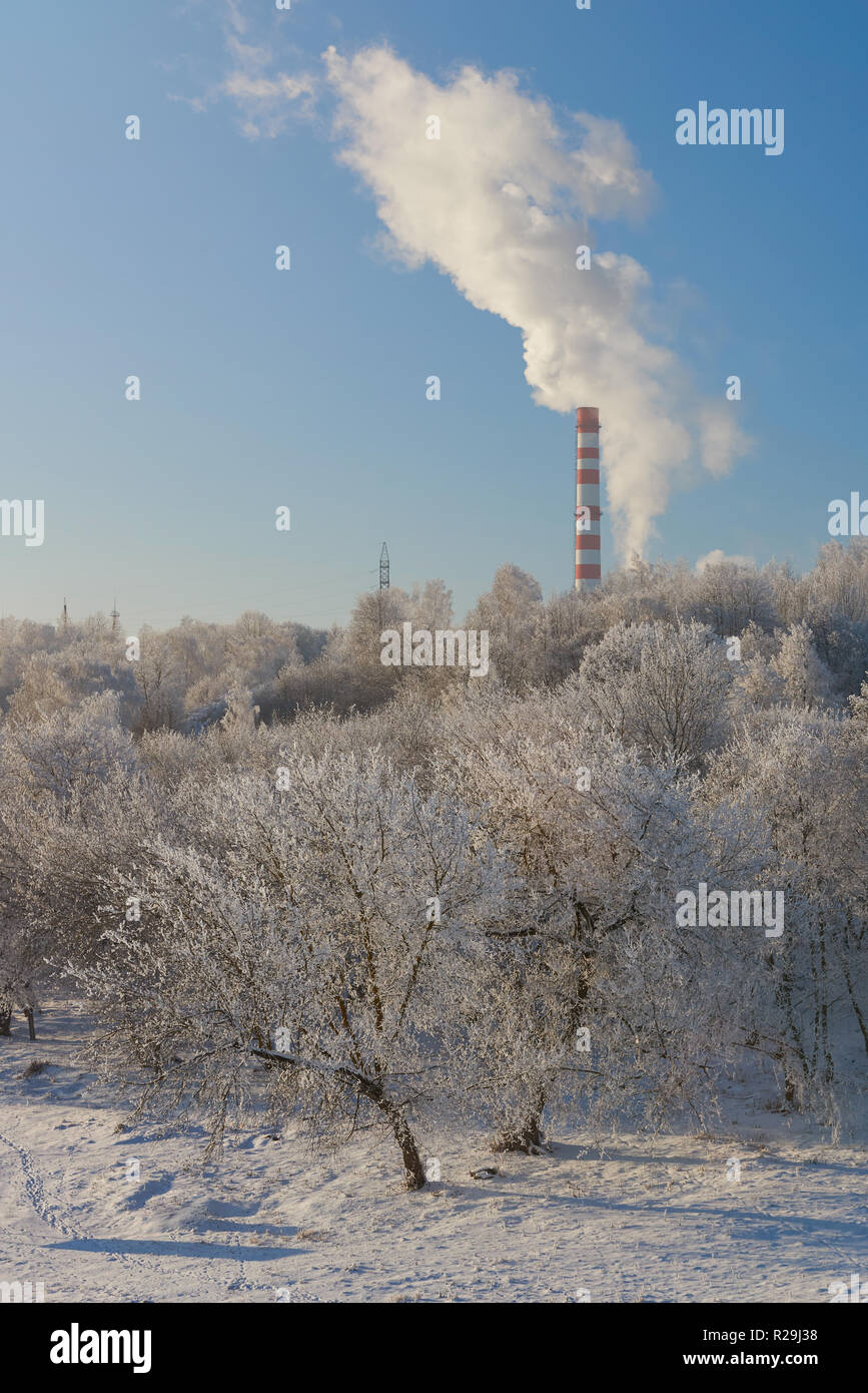 Smoke coming from power factory in winter blue sky background Stock Photo