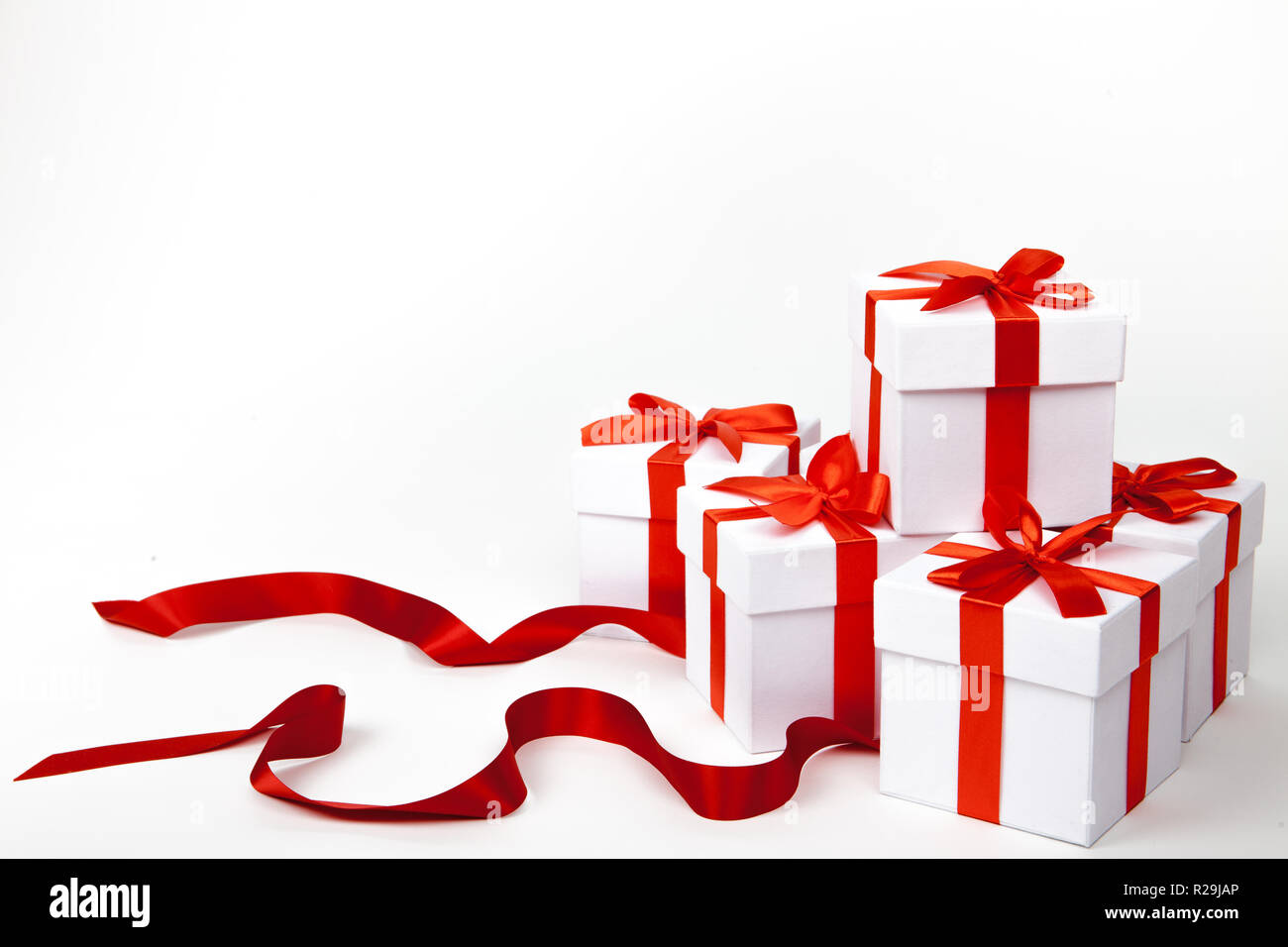 White boxes with a red satin ribbon bow Isolated on white background ...