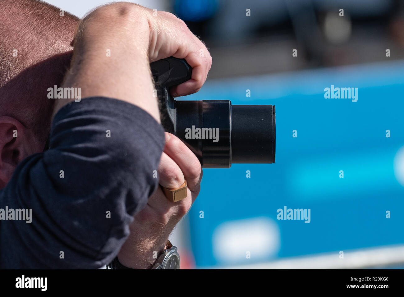 A man takes a picture with two hands holding a camera in front of his face. Stock Photo