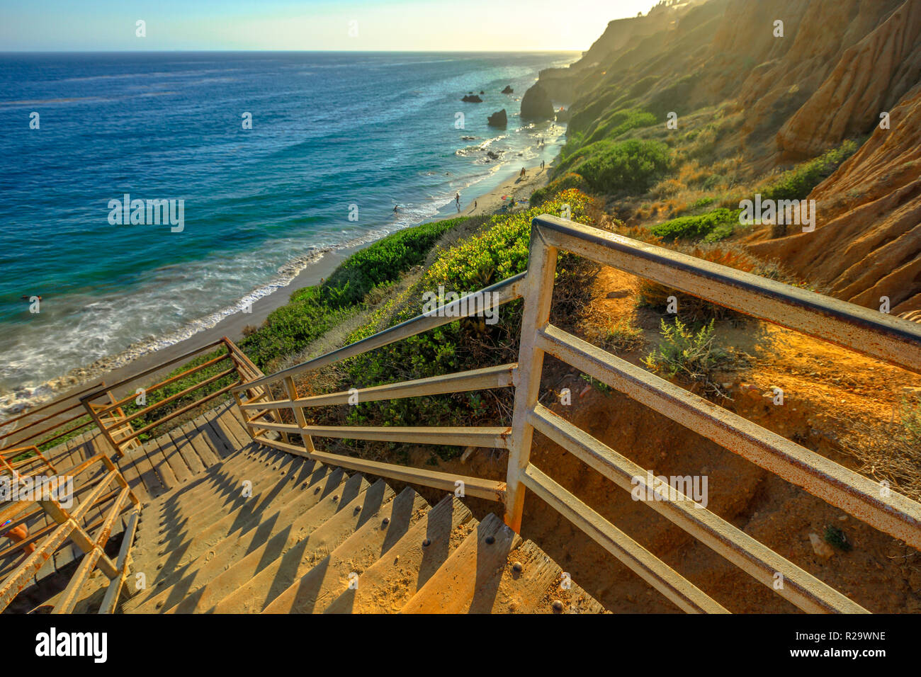 Scenic wooden stairway leading down to El Matador State Beach at sunlight. Pacific coast, California, United States. Pillars and rock formations of most photographed Malibu beach, popular spot shot. Stock Photo