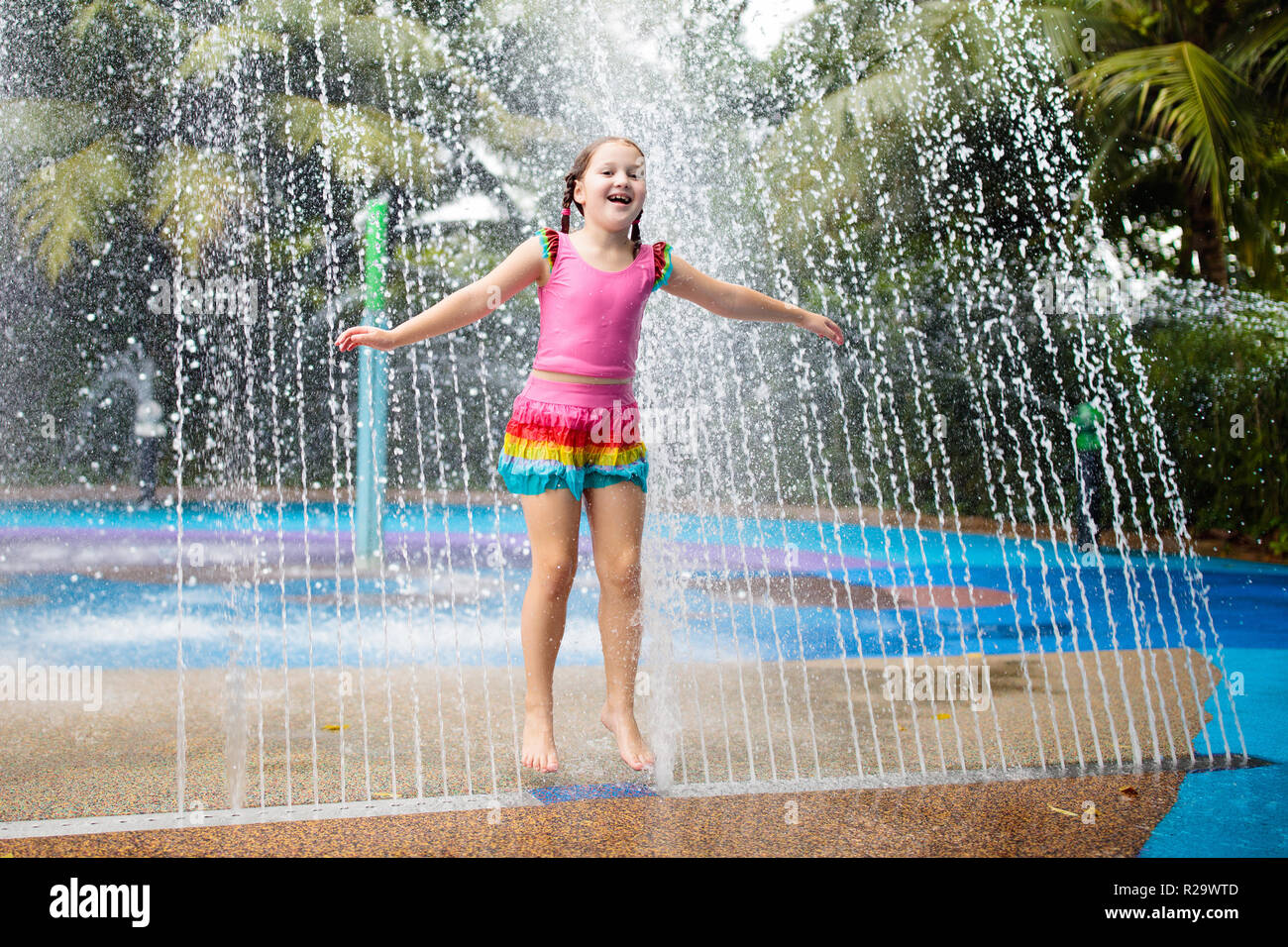 Kids play in aqua park. Children at water playground of tropical