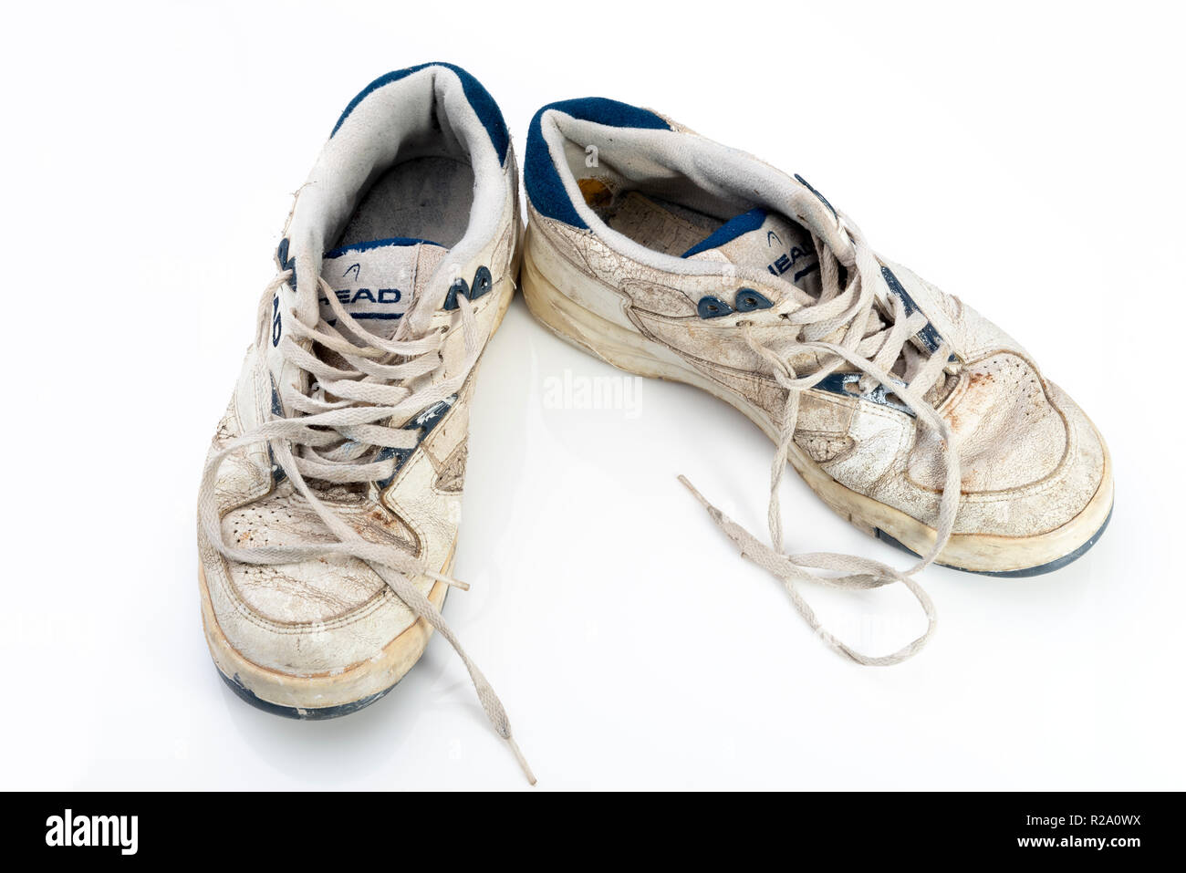 Pair of retro dirty old trainers. Worn and battered sneakers. Stock Photo